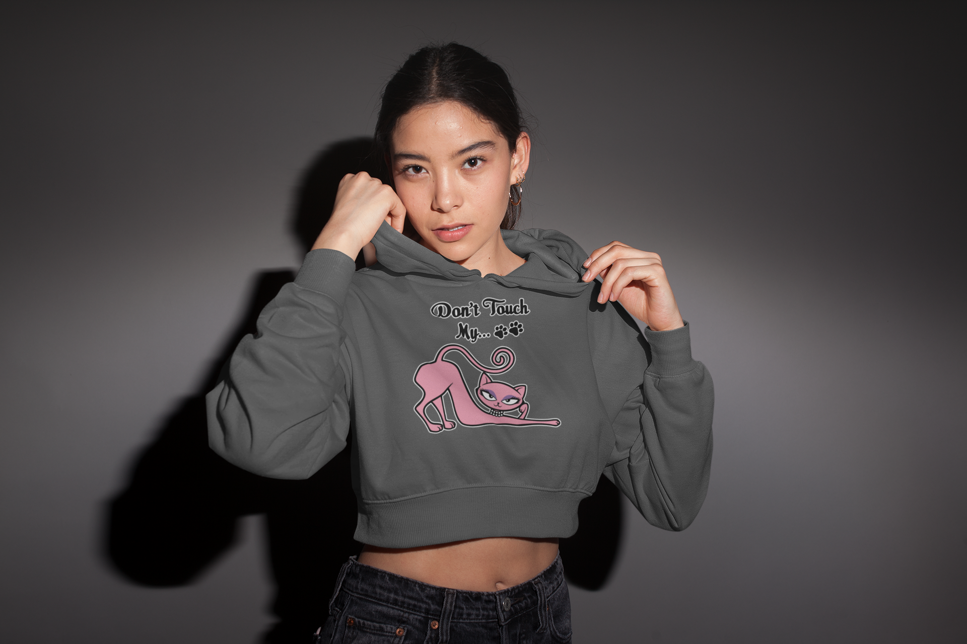 Person wearing a gray hoodie with a graphic design on a dark background