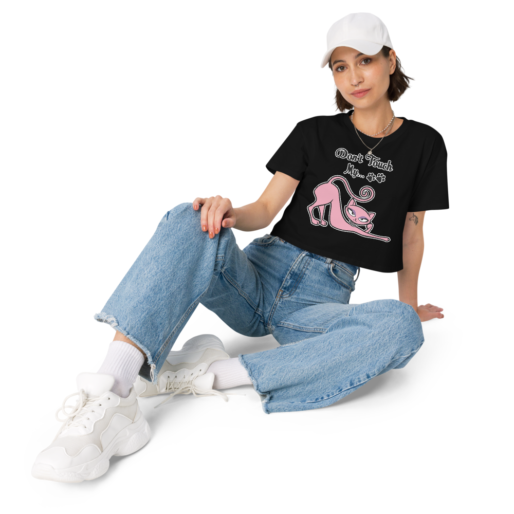 Woman seated in a black Don’t Touch My Kitty crop top with pink cat artwork.